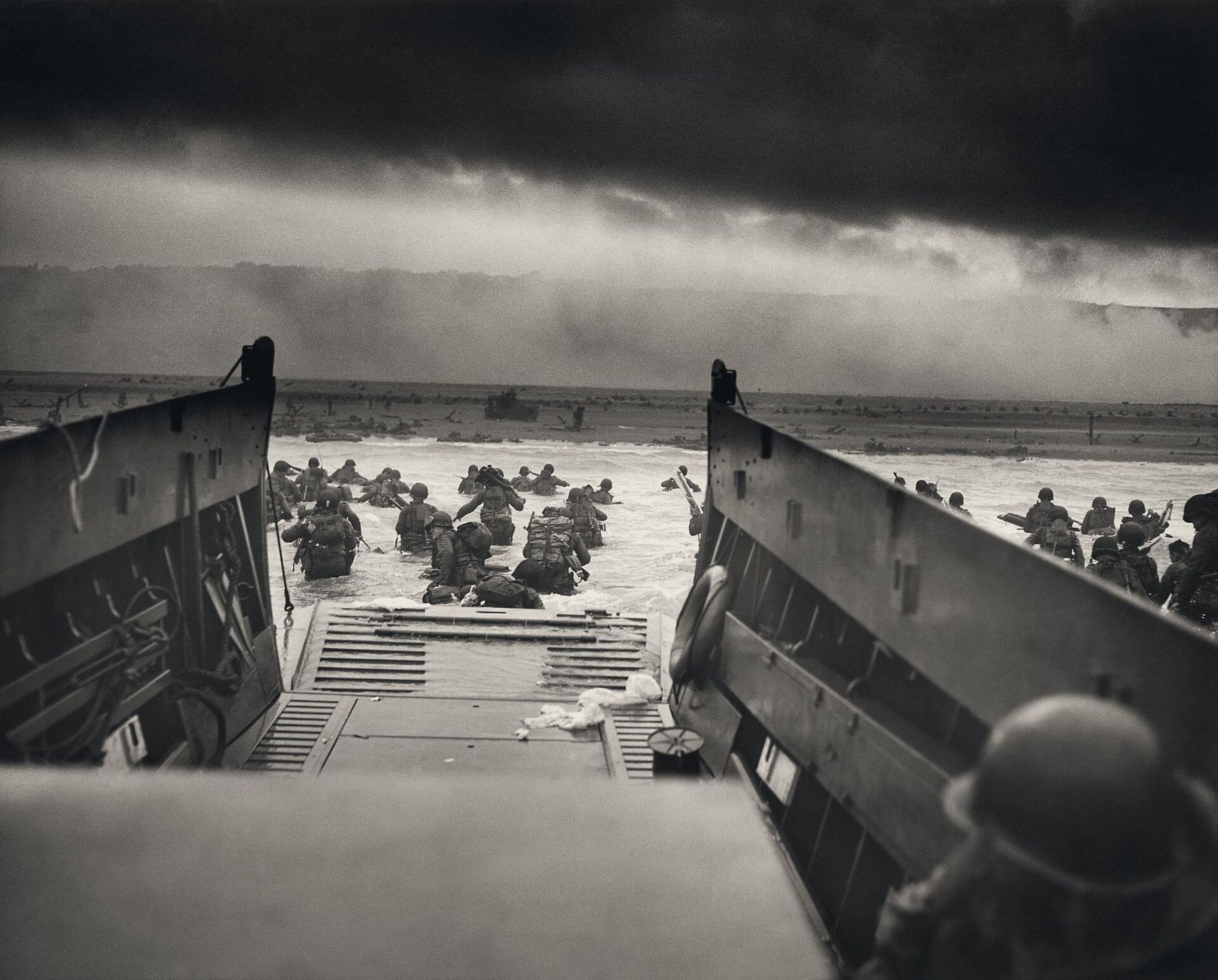 Omaha Beach, 6 juin 1944 : des soldats quittent une barge et avancent dans l’eau vers la plage.